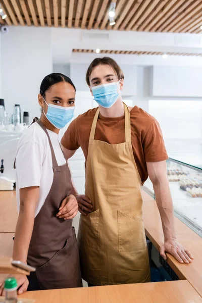 Interracial Sellers Medical Masks Looking Camera Confectionery — Stock Photo, Image