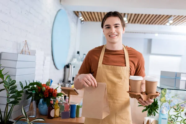 Positive Salesman Holding Coffee Paper Bag Confectionery — Photo