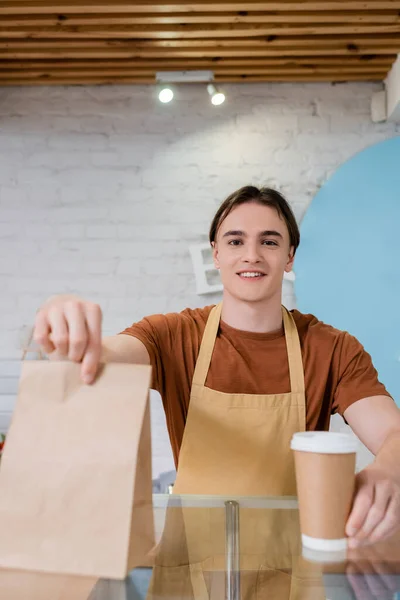 Cheerful Seller Looking Camera While Holding Coffee Paper Bag Sweet — Fotografia de Stock