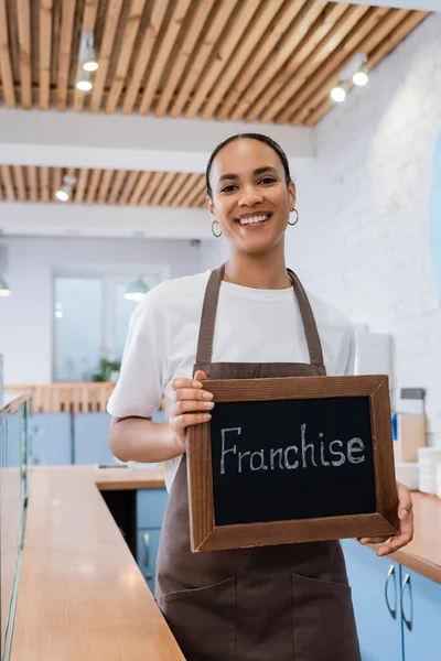 Pozitivní Africká Americká Baristka Držící Tabuli Franšízovým Nápisem Cukrárně — Stock fotografie