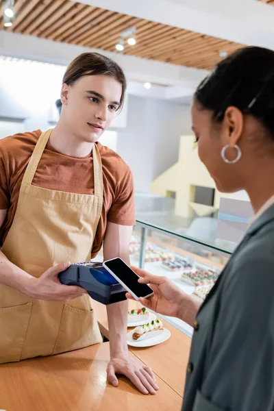 Young Salesman Holding Payment Terminal African American Customer Smartphone Confectionery — Foto de Stock