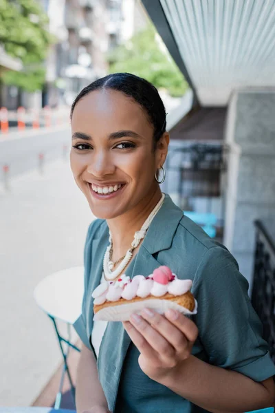 Positive African American Customer Holding Blurred Eclair Terrace Sweet Shop — Fotografia de Stock