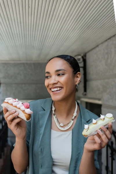 Cheerful Young African American Woman Holding Eclairs Cream Sweet Shop — Fotografia de Stock