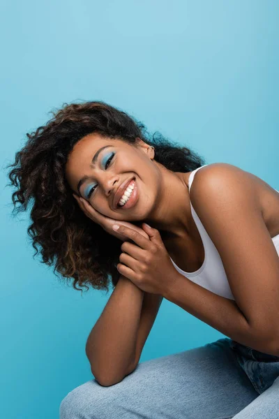 Cheerful African American Woman Blue Eye Shadows Holding Hand Face — Stock Fotó