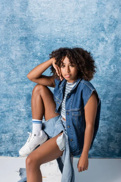 African American Woman Fashionable Denim Clothes Sitting Looking Camera Blue – stockfoto
