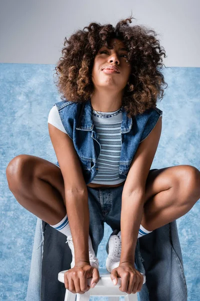 Stylish African American Woman Denim Clothing Sitting Haunches Pouting Lips — 스톡 사진