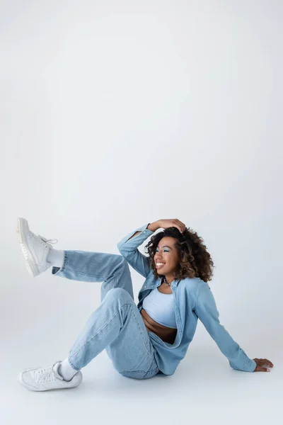 Cheerful African American Woman Denim Clothes Touching Wavy Hair While – stockfoto