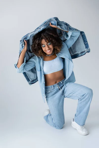Cheerful African American Woman White Crop Top Jeans Holding Denim — стоковое фото