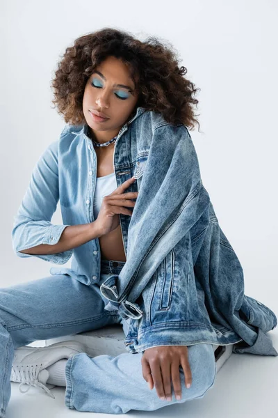 Trendy African American Woman Makeup Closed Eyes Sitting Denim Clothes — 图库照片