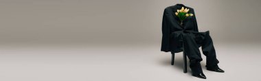 blooming fresh tulips and blue stylish suit hanging on chair on grey background, banner
