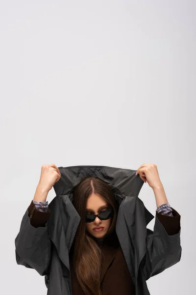 Stylish Teenage Model Sunglasses Adjusting Collar Trench Coat Isolated Grey — Stock Photo, Image