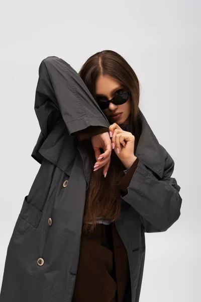 Stylish Teenage Model Sunglasses Adjusting Organic Sleeve Trench Coat Isolated — Stockfoto