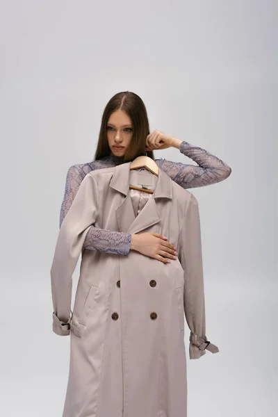 Pretty Teenage Model Holding Recyclable Trench Coat Hanger Isolated Grey — 스톡 사진