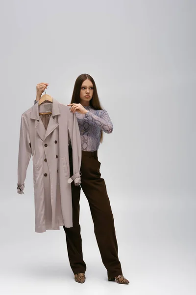 Full Length Teenage Model Holding Recyclable Trench Coat Hanger Grey — Stockfoto