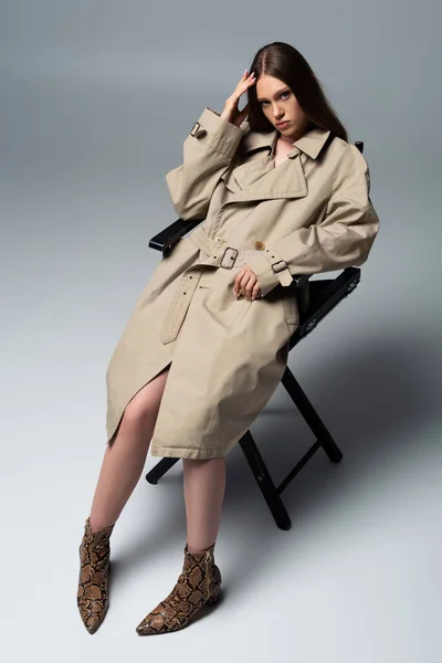 Full Length Model Stylish Trench Coat Posing Chair Grey — Stockfoto