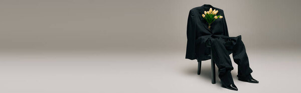 Цветущие свежие тюльпаны и синий стильный костюм, висящий на стуле на сером фоне, баннер