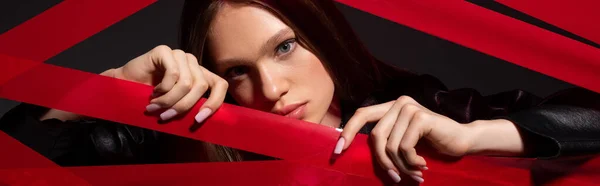 Pretty Model Touching Red Strips Duct Tape Isolated Black Banner — Stockfoto