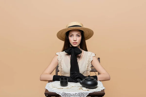 Stylish Woman Gloves Sun Hat Looking Camera Teapot Cup Table — Stock Fotó