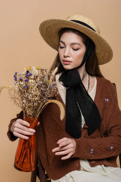 Trendy Woman Sun Hat Looking Flowers Vase Isolated Beige — Stockfoto
