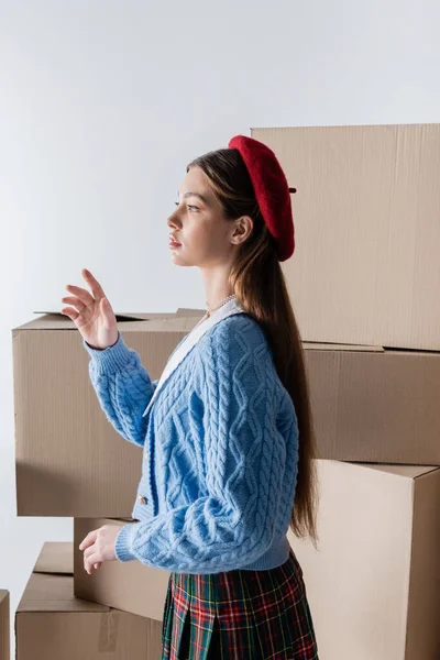 Side View Trendy Woman Beret Knitted Cardigan Standing Carton Boxes — Stockfoto