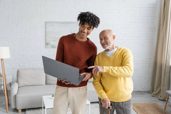 Senior Man Walking Cane Pointing Finger African American Grandson Laptop — Stockfoto