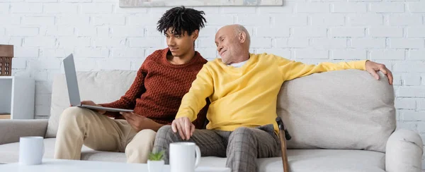 Smiling Senior Man Looking Laptop African American Grandson Cups Home — Stock Photo, Image