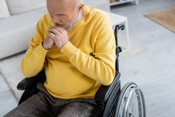 Sad elderly man sitting in wheelchair at home