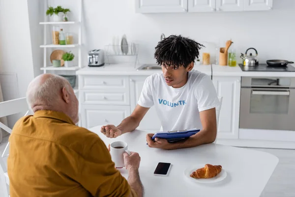 African American Volunteer Clipboard Talking Senior Man Tea Kitchen — Foto de Stock