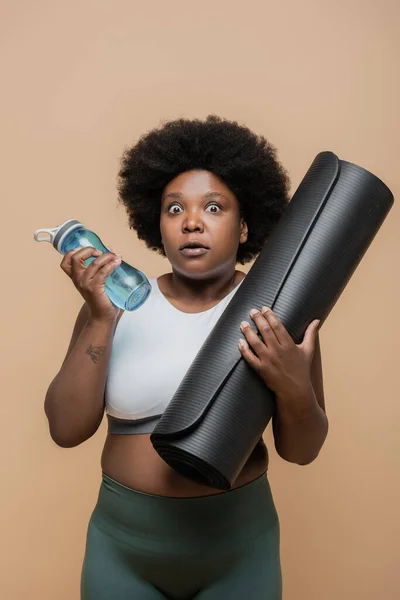 Shocked African American Size Woman Crop Top Holding Fitness Mat — 스톡 사진