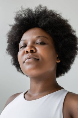 low angle view of confident african american plus size woman in sportswear isolated on grey