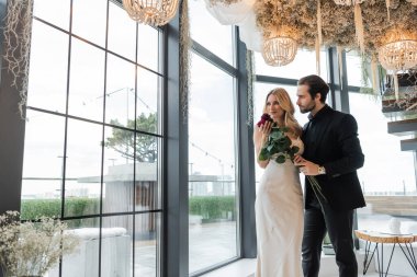 Elegant couple holding roses during date in restaurant 
