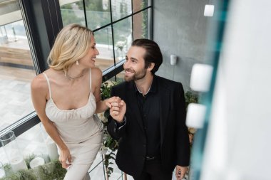 Smiling elegant couple holding hands in restaurant 