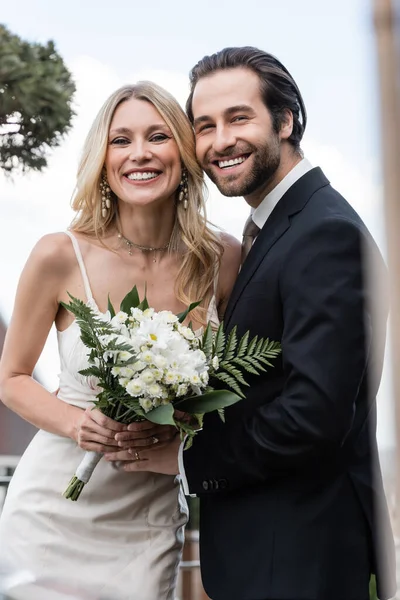 Happy Newlyweds Bouquet Smiling Camera Outdoors — Stok fotoğraf