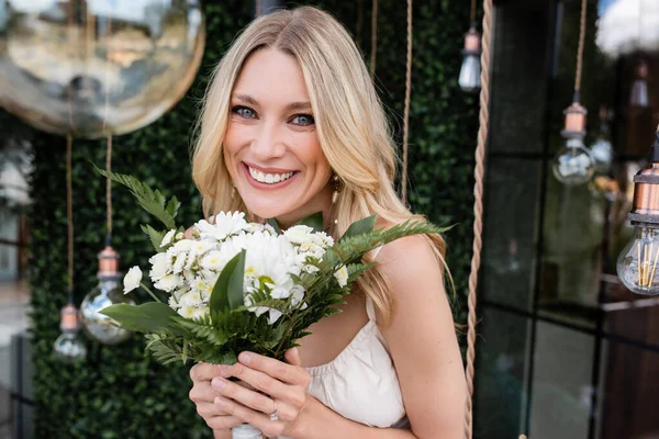 Portrait Positive Bride Holding Bouquet Looking Camera Blurred Light Bulbs — Stockfoto
