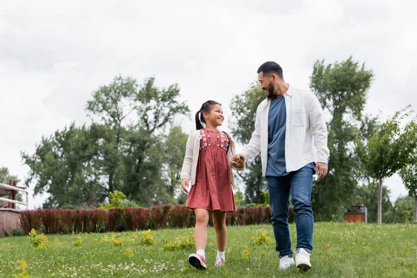 Positive Asian Family Holding Hands While Walking Summer Park — Stockfoto