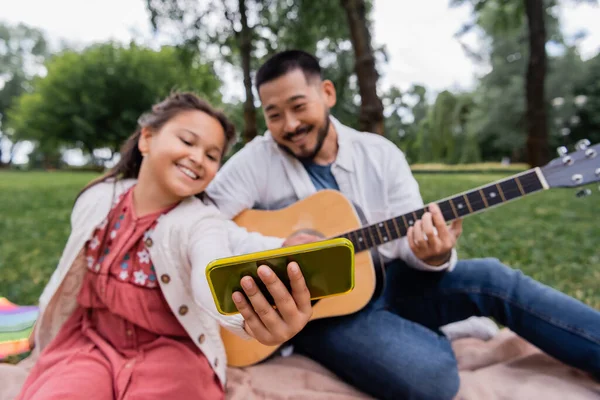 Blurred Asian Child Taking Selfie Smartphone Father Playing Acoustic Guitar — Foto de Stock