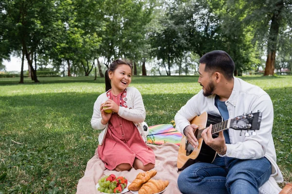 Cheerful Asian Girl Holding Apple Father Playing Acoustic Guitar Park —  Fotos de Stock