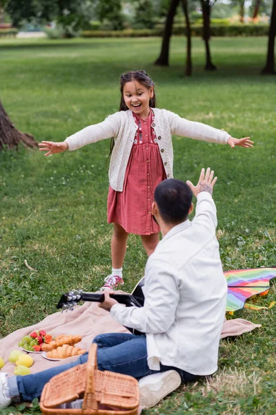 Positive Asian Girl Looking Dad Holding Acoustic Guitar Food Blanket — 图库照片