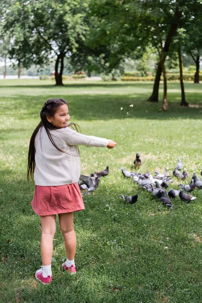 Cheerful Asian Girl Feeding Blurred Doves Park — Foto de Stock