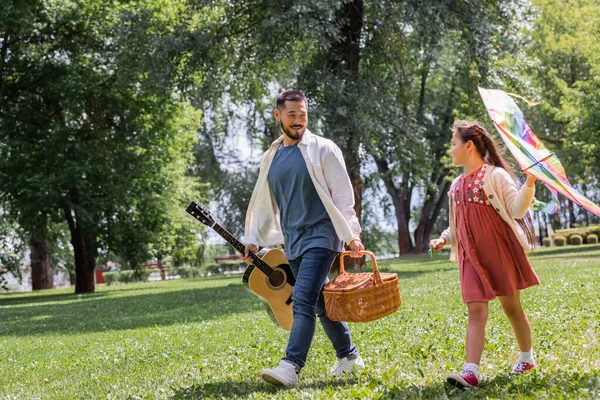 Asian Kid Holding Flying Kite Dad Basket Acoustic Guitar Park — Foto de Stock