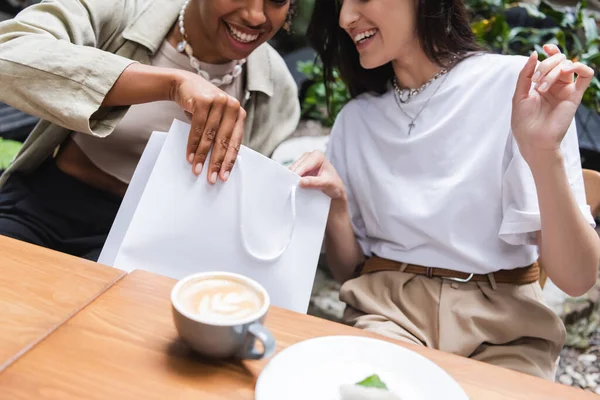 Cropped View Multiethnic Girlfriends Holding Shopping Bag Coffee Outdoor Cafe — Zdjęcie stockowe