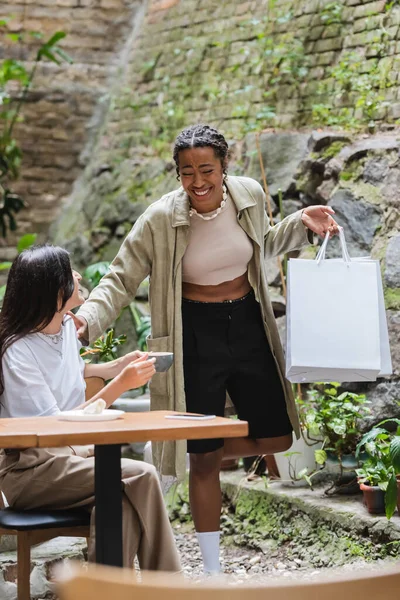 Positive African American Woman Holding Shopping Bags Friend Coffee Outdoor — Fotografia de Stock