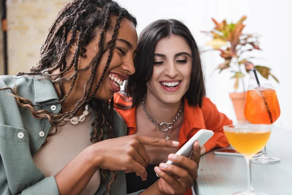 African American Woman Pointing Smartphone Girlfriend Cocktails Cafe — Stockfoto