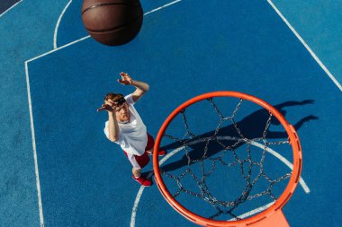 top view of young man playing basketball on modern court