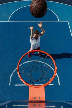 top view of man throwing ball into basketball hoop clipart