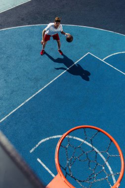 high angle view of young sportive man training on basketball court