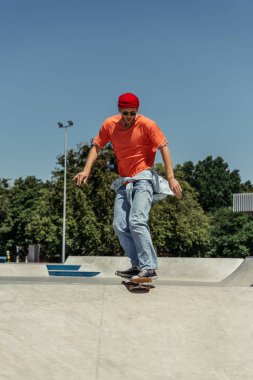 full length of man in trendy outfit training in skate park