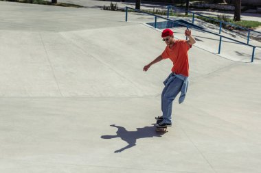 full length of fashionable young man riding skate outdoors