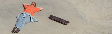 high angle view of trendy skater relaxing near skateboard, banner