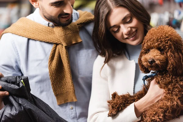 Blurred Interracial Couple Holding Poodle Animal Jacket Pet Shop —  Fotos de Stock